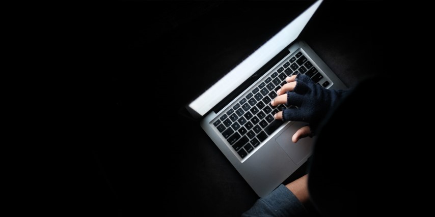 Close up of a laptop being used in the dark with hidden display.