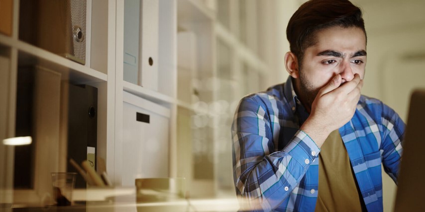 A victim of a successful network attack sitting at a laptop.